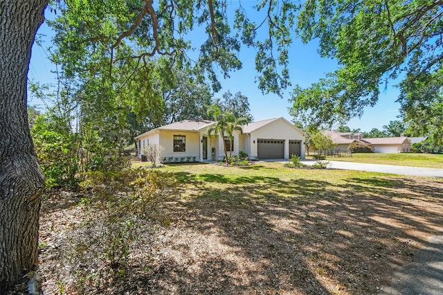 single story home with a garage, stucco siding, and concrete driveway