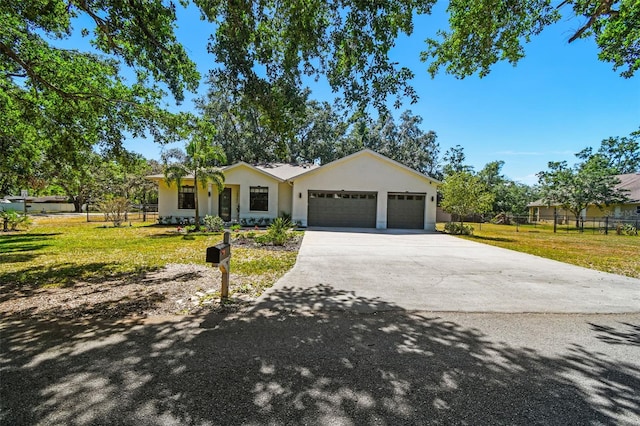 ranch-style home featuring stucco siding, a garage, driveway, and a front lawn