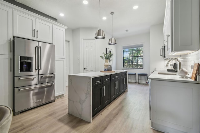 kitchen featuring a kitchen island, light wood-style floors, high quality fridge, recessed lighting, and backsplash