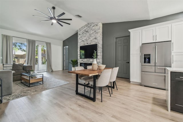 dining room featuring light wood-type flooring, ceiling fan, vaulted ceiling, and visible vents