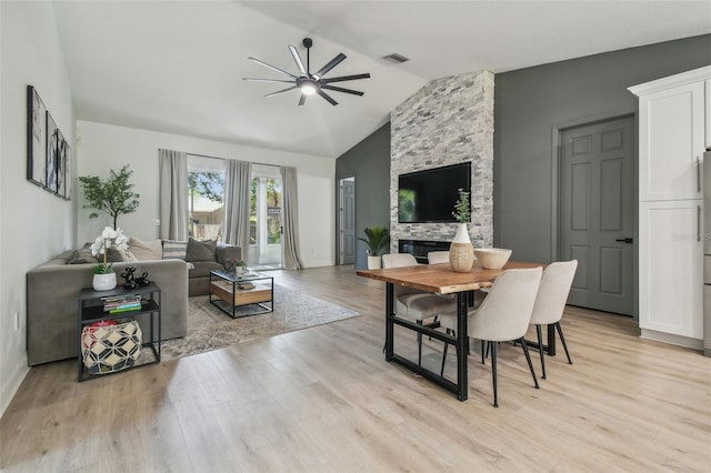 dining area with visible vents, light wood-style floors, ceiling fan, and vaulted ceiling