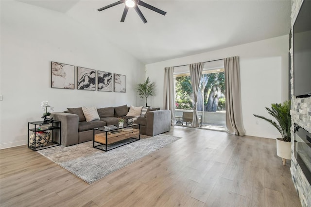 living area with baseboards, a ceiling fan, wood finished floors, and vaulted ceiling
