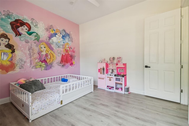 bedroom with baseboards and wood finished floors
