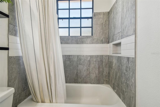 bathroom with shower / bath combo with shower curtain and toilet