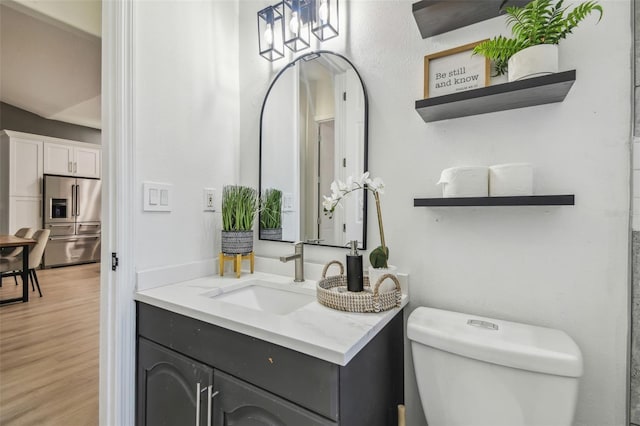 bathroom with vanity, wood finished floors, and toilet