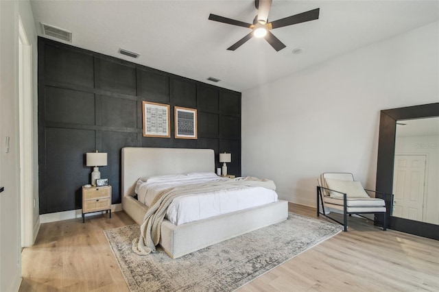 bedroom featuring baseboards, light wood-style flooring, and visible vents