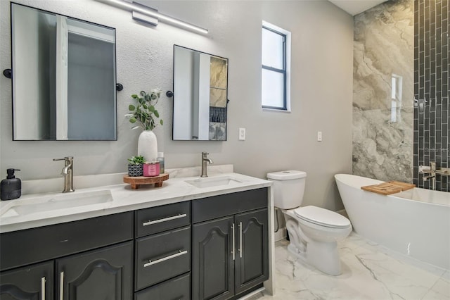 bathroom with toilet, a freestanding tub, a sink, and marble finish floor