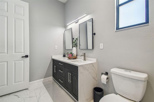 bathroom featuring double vanity, a sink, marble finish floor, and toilet