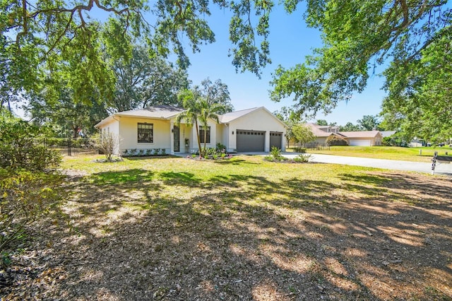 ranch-style house with a garage, fence, a front yard, and concrete driveway