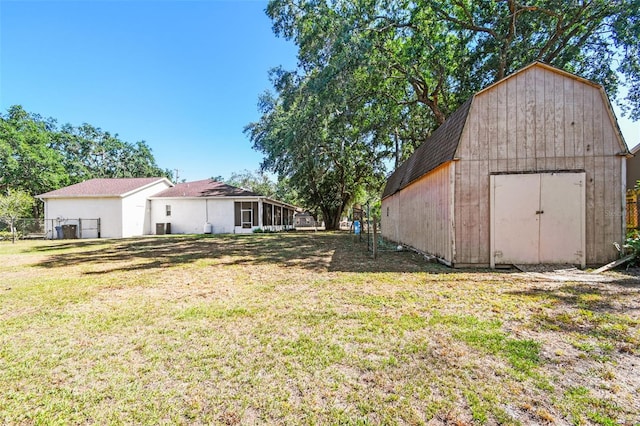 view of yard featuring fence, an outdoor structure, cooling unit, and a shed
