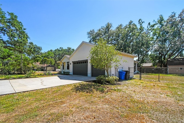 view of side of property featuring fence, a garage, stucco siding, concrete driveway, and a lawn