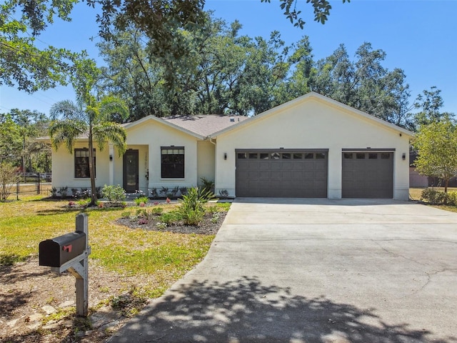 single story home with fence, a front lawn, concrete driveway, an attached garage, and stucco siding
