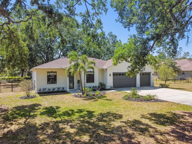 ranch-style home with driveway, a front yard, fence, an attached garage, and stucco siding