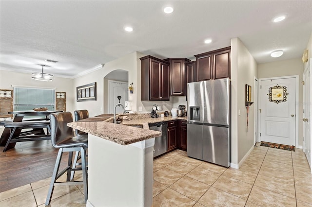 11871 Crestridge Loop, Trinity, FL 34655 - kitchen with a sink, a peninsula, a breakfast bar area, arched walkways, and stainless steel appliances