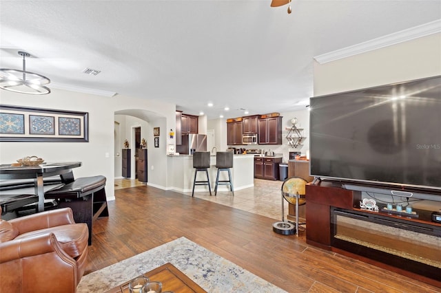11871 Crestridge Loop, Trinity, FL 34655 - living room with visible vents, arched walkways, wood finished floors, and ornamental molding