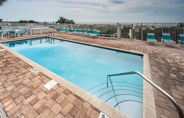 pool featuring fence and a patio