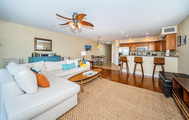 living area featuring visible vents, a ceiling fan, wood finished floors, and recessed lighting
