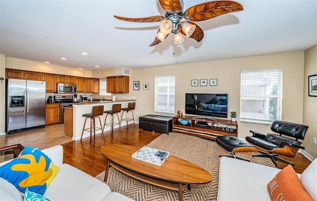 living area with baseboards, a ceiling fan, recessed lighting, and visible vents