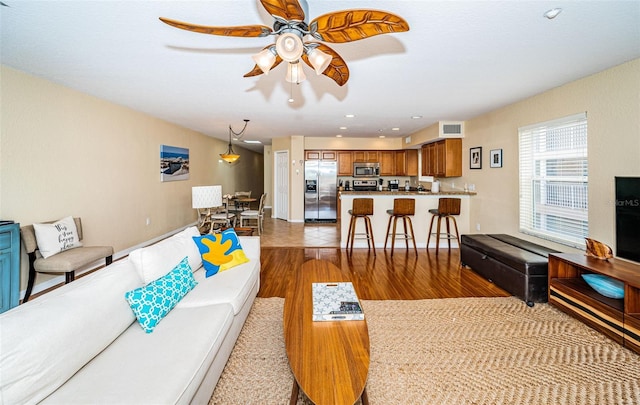 living area featuring a ceiling fan, recessed lighting, wood finished floors, and visible vents