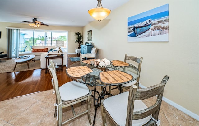 dining space featuring a ceiling fan and baseboards