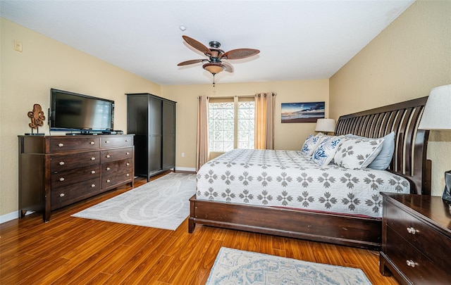 bedroom with baseboards, ceiling fan, and wood finished floors