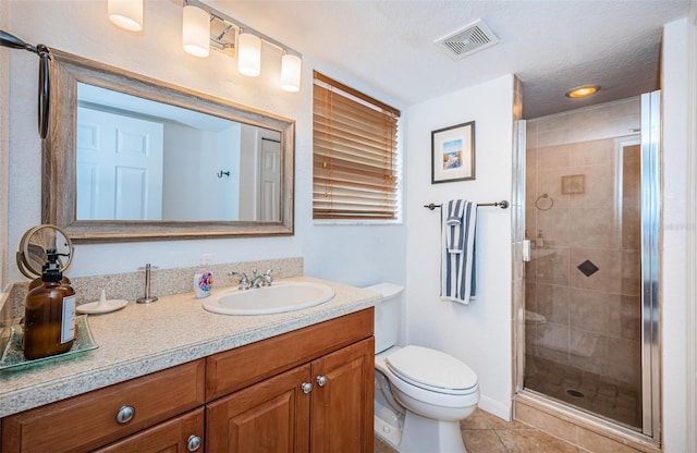 full bath with visible vents, a stall shower, vanity, tile patterned floors, and toilet