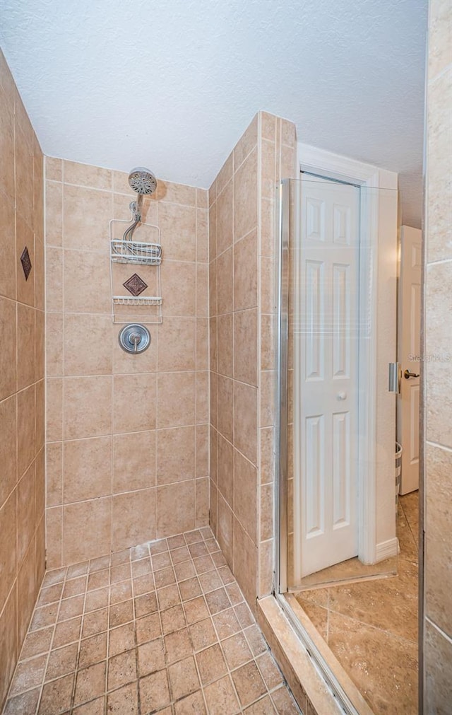bathroom featuring a textured ceiling and a stall shower