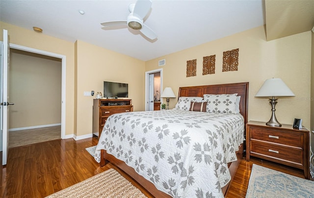 bedroom with a ceiling fan, baseboards, dark wood finished floors, and visible vents