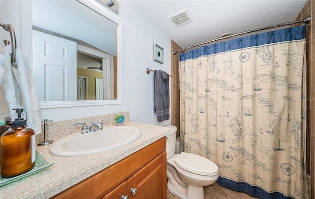 bathroom with visible vents, tile patterned flooring, vanity, toilet, and a textured ceiling