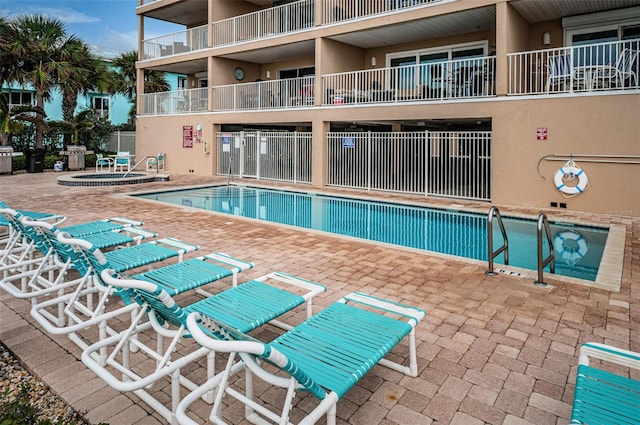 community pool featuring a patio area and fence