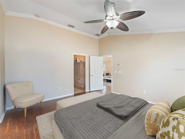 bedroom with crown molding, visible vents, wood finished floors, baseboards, and a spacious closet