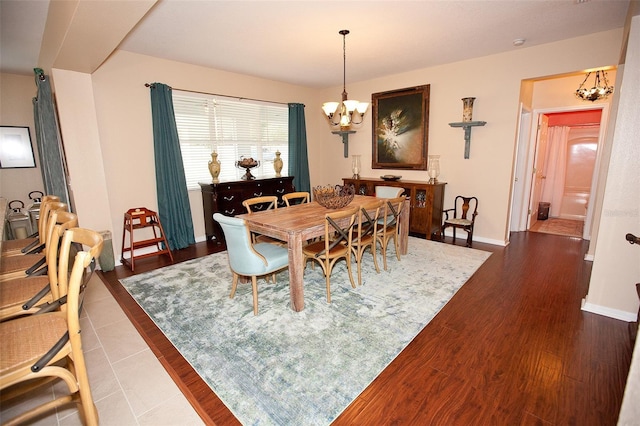 dining area with baseboards, dark wood-style flooring, and a notable chandelier