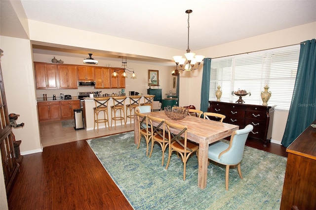 dining space with baseboards, an inviting chandelier, and dark wood finished floors