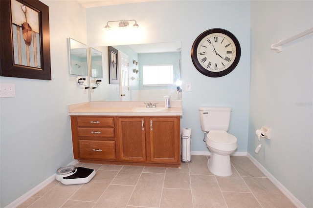 bathroom with tile patterned floors, baseboards, vanity, and toilet