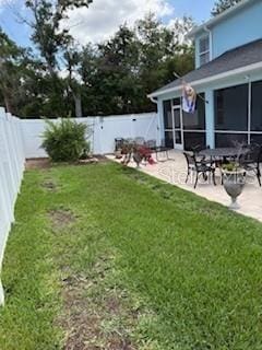 view of yard featuring a patio, a fenced backyard, and a sunroom