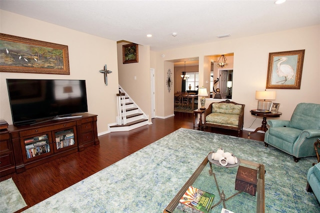 living room with an inviting chandelier, recessed lighting, stairs, and wood finished floors