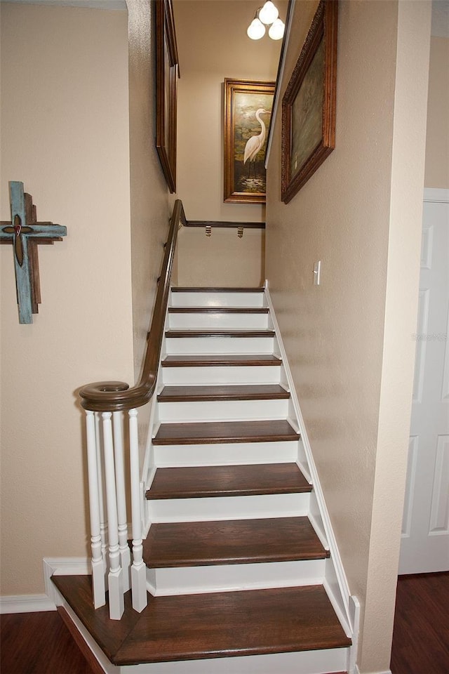stairway with baseboards and wood finished floors