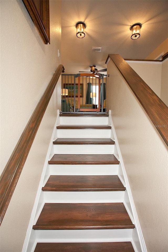 stairway featuring visible vents and ceiling fan
