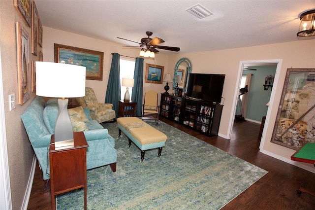 living room featuring baseboards, ceiling fan, visible vents, and wood finished floors