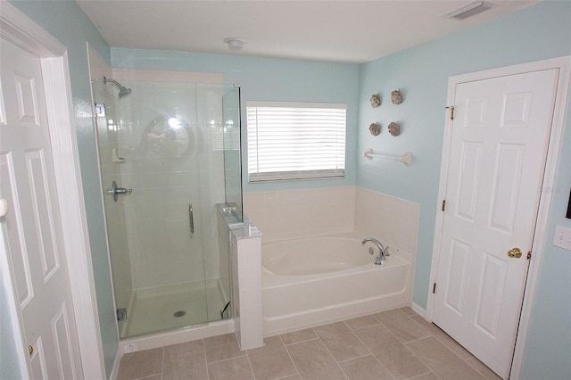 bathroom featuring tile patterned floors, a shower stall, a garden tub, and visible vents