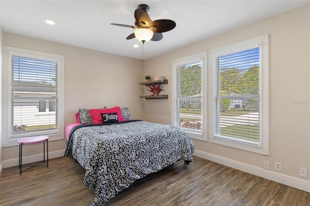 bedroom featuring multiple windows, baseboards, wood finished floors, and recessed lighting