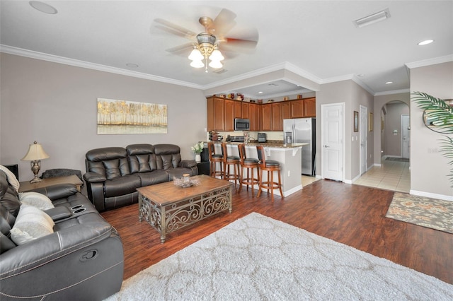 6902 47th Ln N, Pinellas Park, FL 33781 - living area with crown molding, ceiling fan, arched walkways, light wood-style flooring, and visible vents