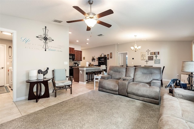 living room with light tile patterned flooring, ceiling fan with notable chandelier, and visible vents