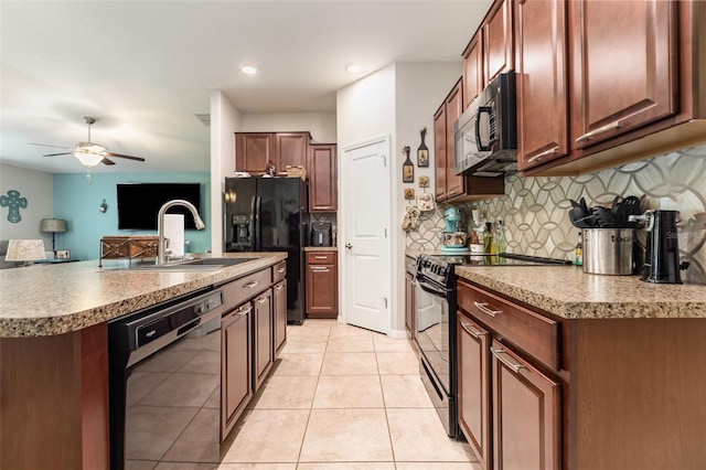kitchen with ceiling fan, a sink, decorative backsplash, black appliances, and a center island with sink