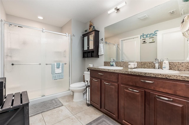 full bath featuring a sink, tile patterned flooring, toilet, and a stall shower