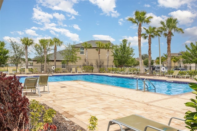 community pool featuring fence and a patio