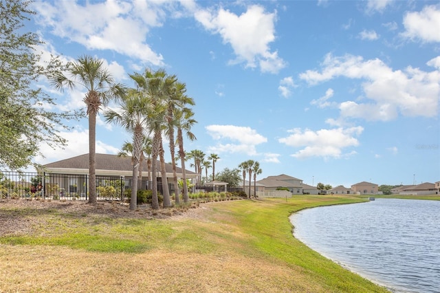 exterior space with a water view, a residential view, and fence