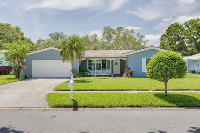 ranch-style home featuring a garage, covered porch, driveway, a front lawn, and cooling unit