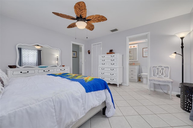 bedroom featuring light tile patterned floors, ensuite bath, ceiling fan, and baseboards