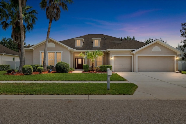 11845 Newberry Grove Loop, Riverview, FL 33579 - traditional-style home featuring a garage, driveway, stucco siding, a front yard, and roof with shingles